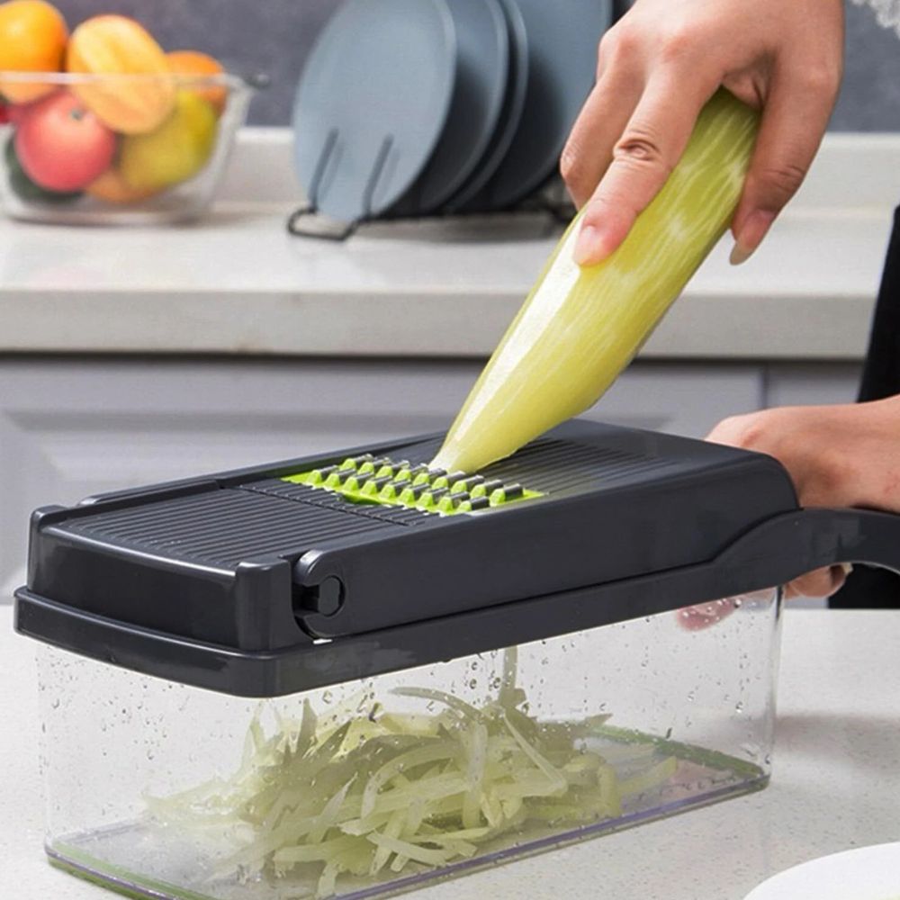 Person using a mandoline slicer to slice a cucumber on a kitchen counter.