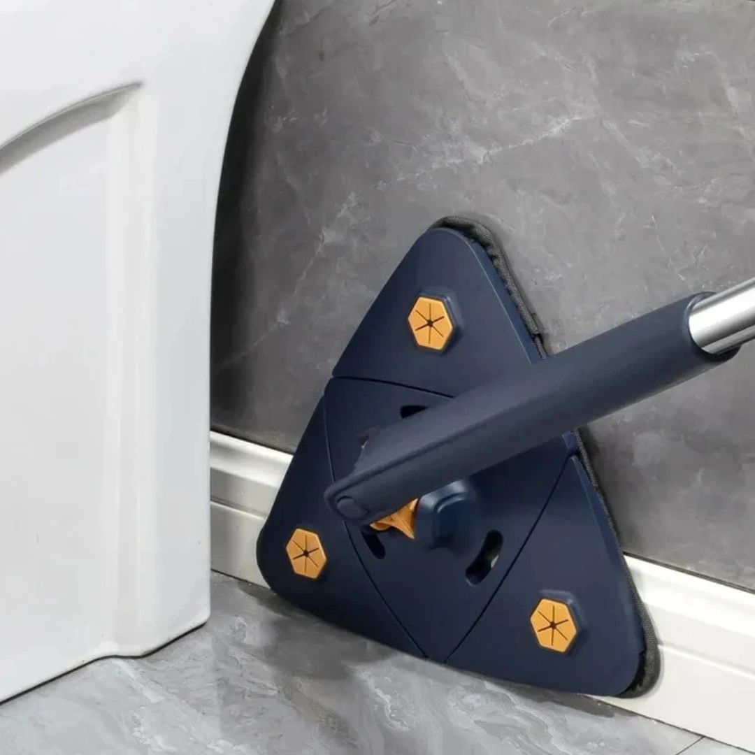 Blue cleaning tool with yellow hexagonal patterns being used to clean a corner of a room.