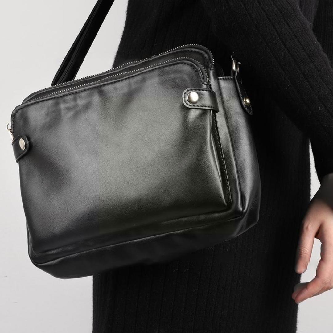 Women's leather crossbody bag worn across body in busy crowd