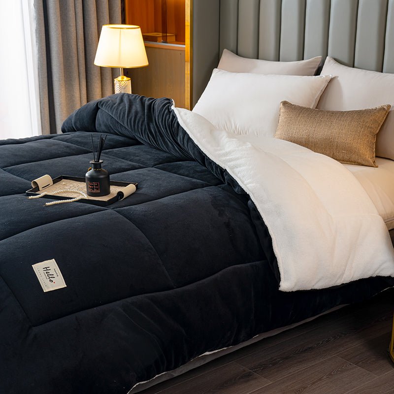 Bed with navy comforter, white pillows, and a lamp in a bedroom setting.