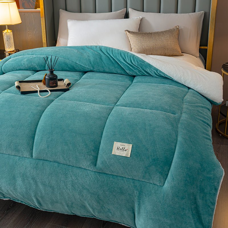 Teal comforter on a bed with a visible brand label in a bedroom setting.